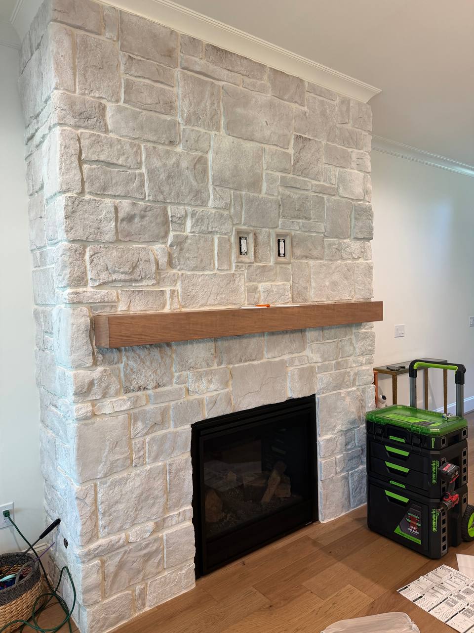 Stone fireplace with mantel before 75-inch LG TV installation in Roxboro, NC